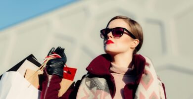 shallow focus photography of woman holding shopping bags during day